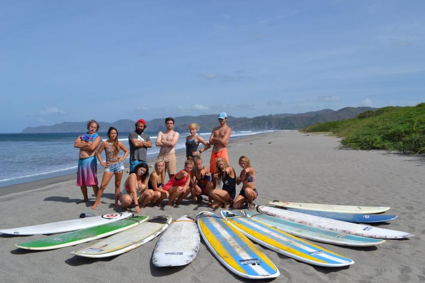 Students on the beach with surfboards