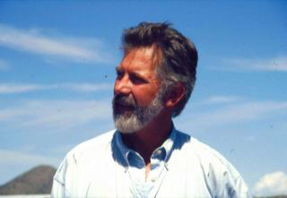 David Hurst Thomas with a scenic background of blue sky and clouds