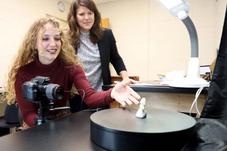 Natalie Moss, left, photographs ancient tooth with associate professor Suzanne Pilaar Birch