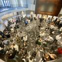 overhead view of poster session. 24 easels arranged in large circle and large crowd observing 