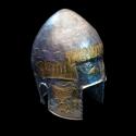 A silver helmet with gold details on a solid black background